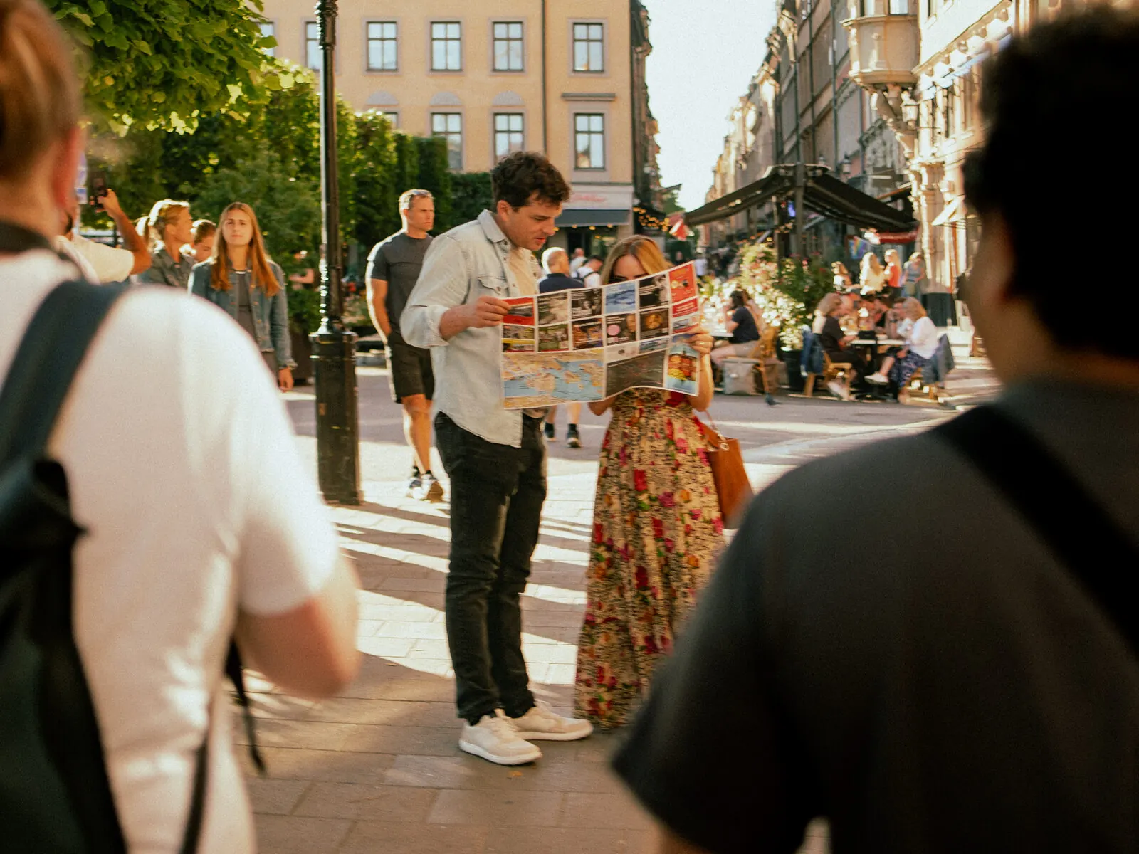 Folk samlade kring en fotograf på en solig gata i Stockholm
